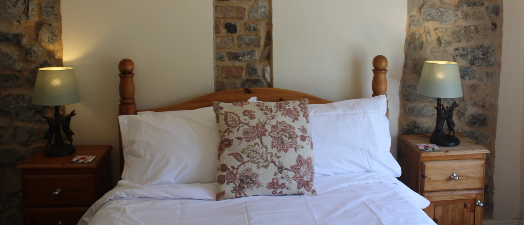 Double bed and exposed stone walls at Kibble Cottage