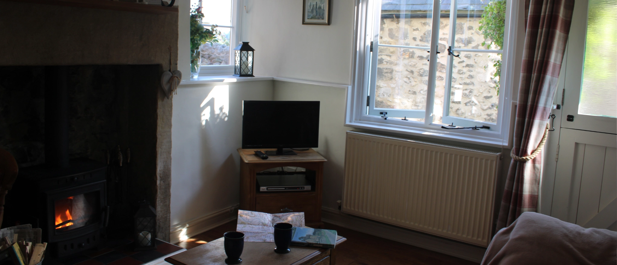 Lounge with wood burner and television at Kibble Cottage